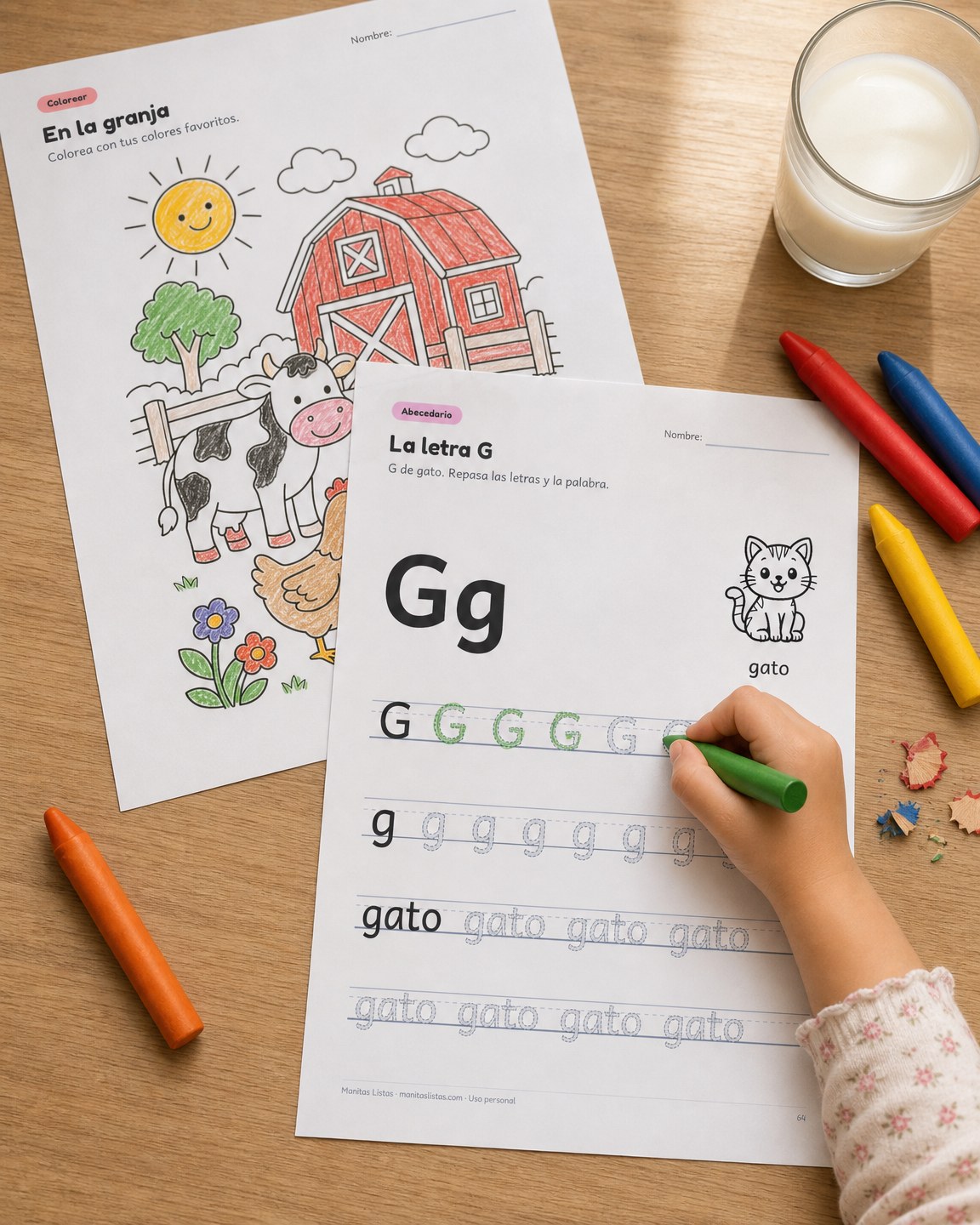 Fichas de Manitas Listas impresas sobre una mesa, con una niña repasando la letra G con crayón verde